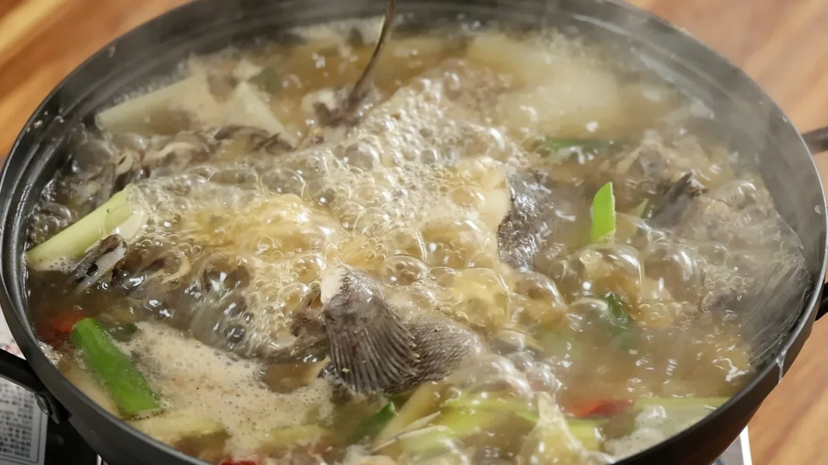 대청도 우럭백숙. 검은 전골 냄비에서 우럭과 대파, 무가 함께 끓고 있다.
