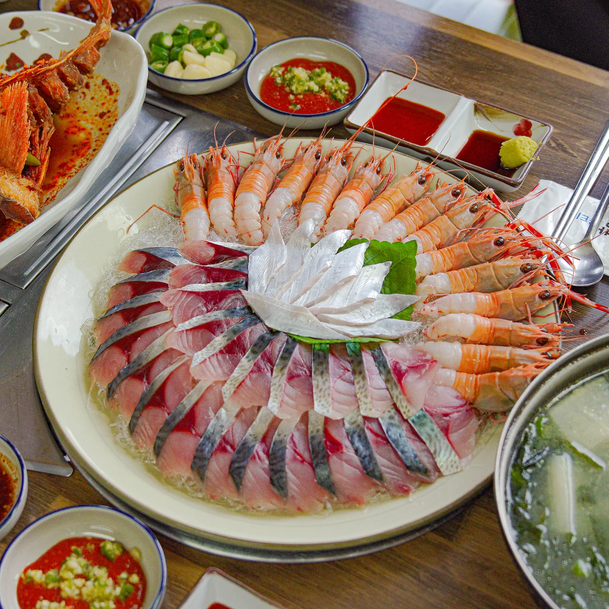큰 접시에 흰 살 회를 원형으로 두르고 가운데에 흰빛 장식을 부채꼴로 폈으며 바깥 테두리는 딱새우로 둘렀다. 초장과 간장 종지가 함께 놓여 있다.