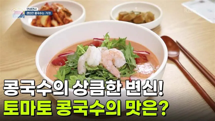 분홍빛 토마토 콩국수 한 그릇에 새우와 루꼴라가 올라가 있다. 자막에 콩국수의 상큼한 변신, 토마토 콩국수의 맛은이라고 적혀 있다.