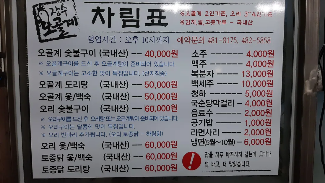 장수오골계숯불구이 차림표 사진. 오골계 숯불구이 40,000원, 오골계 도리탕 50,000원, 오골계 옻백숙 50,000원, 오리 숯불구이 60,000원, 토종닭 옻백숙 60,000원, 라면사리 2,000원, 공기밥 1,000원, 5월부터 10월까지 냉면 6,000원, 예약문 481-8175와 482-5858, 영업시간 오후 10시까지라고 적혀 있다.