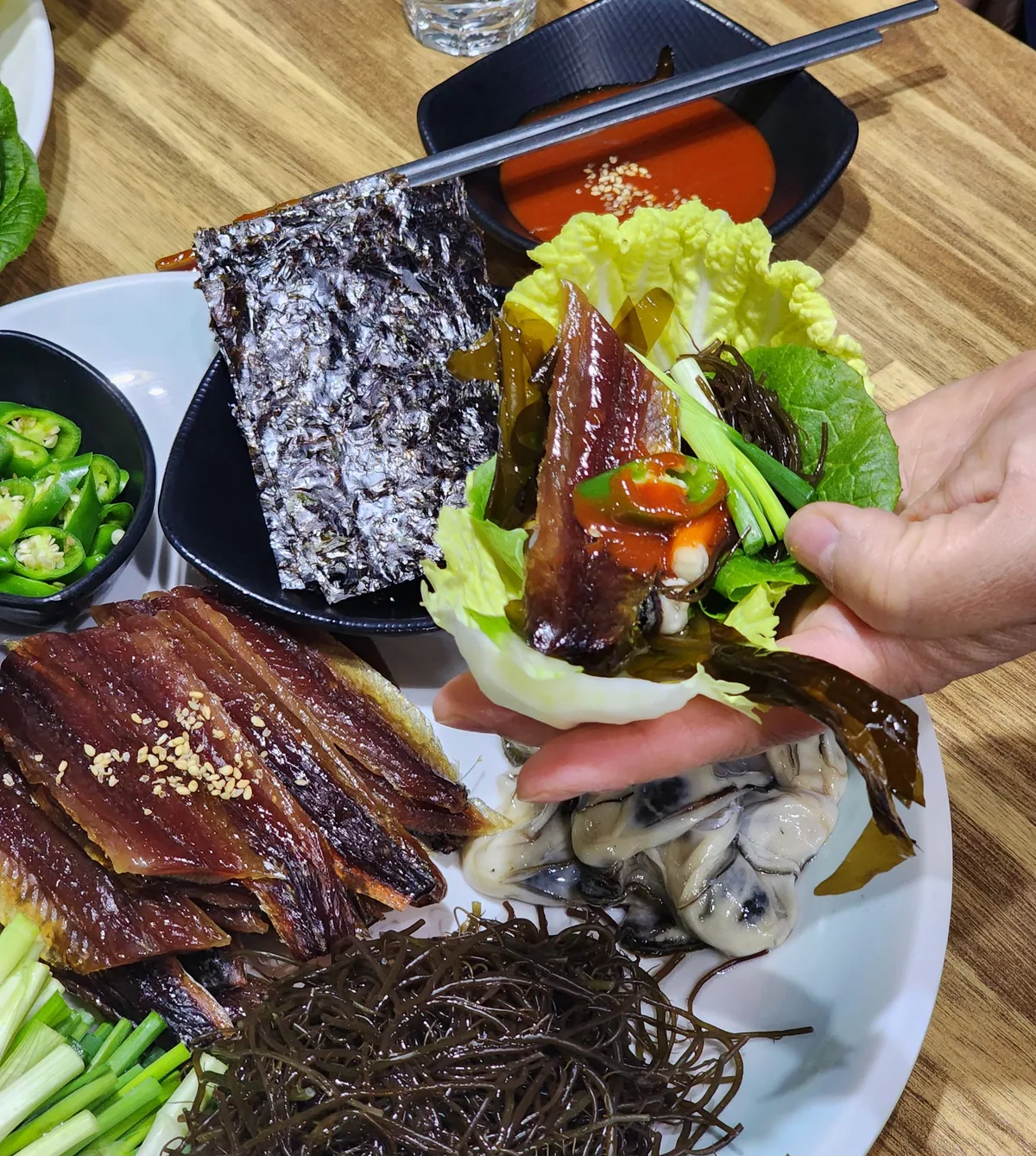 모래성분식포차 계절 음식 과메기 한 상. 말린 생선살에 깨를 뿌리고 김, 물미역, 다시마채, 생굴, 쪽파, 청양고추, 초장, 배추가 함께 나온다. 값은 40,000원이다.