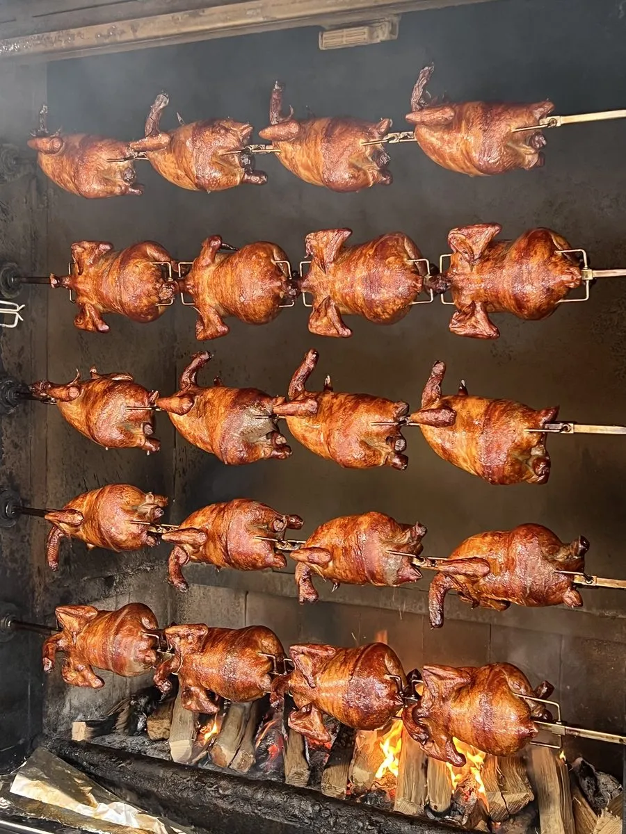 신당 계류관 장작 화덕. 쇠꼬챙이에 꿴 닭이 다섯 줄로 걸려 있고 바닥에는 장작불이 타고 있다.