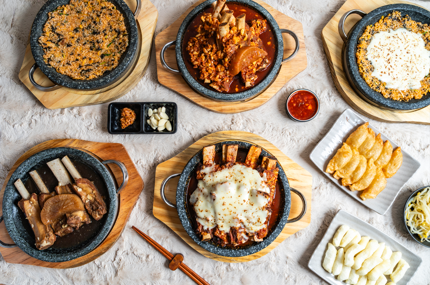 갈비찜 두 판과 치즈볶음밥, 튀김만두, 떡, 콩나물이 오른 상차림 전체