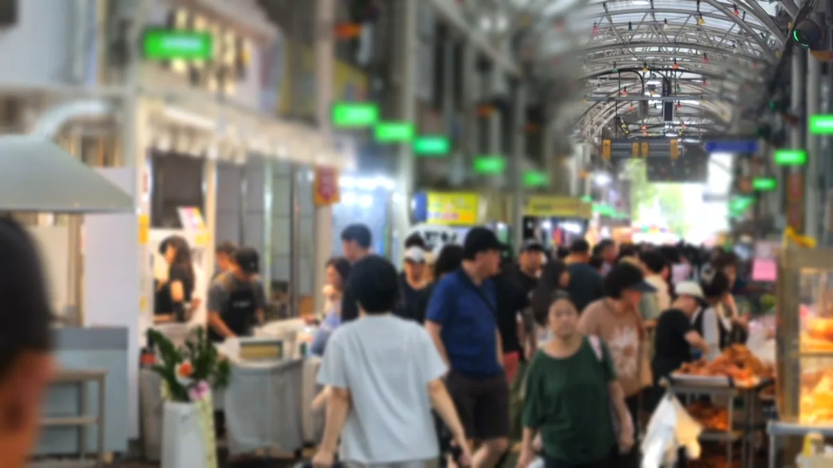 아케이드 지붕 아래 사람들로 붐비는 오산 오색시장 통로.